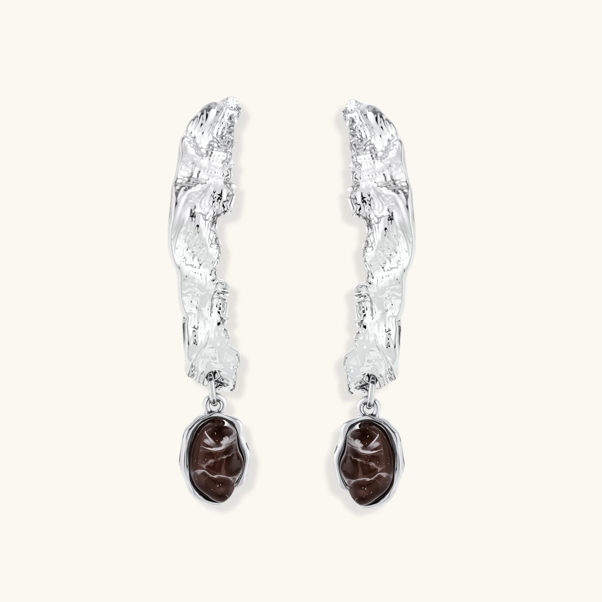 Silver-toned twisted metal earrings with dark brown oval resin stones dangling from sculptural posts on white background.