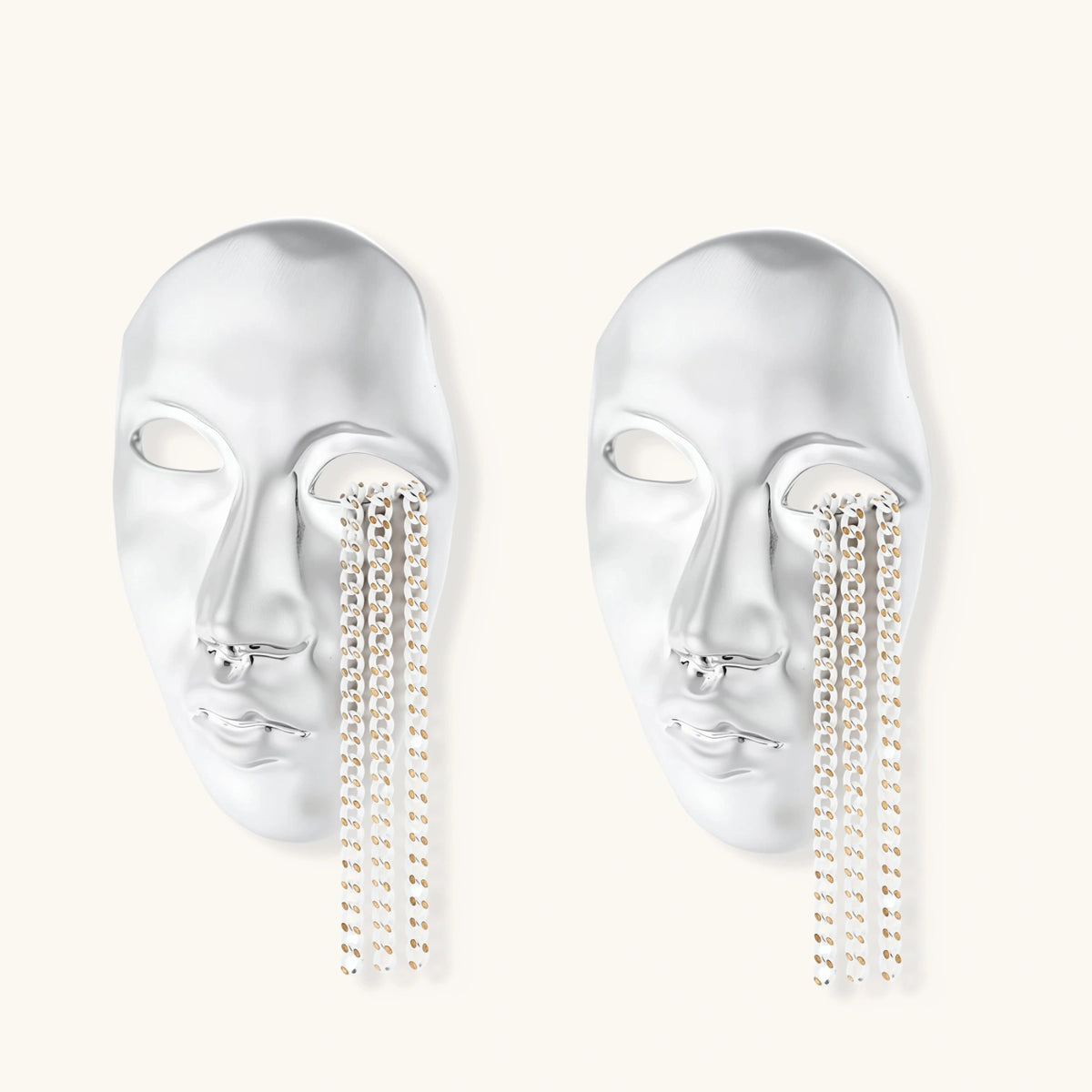 Silver face-shaped statement earrings with flowing chain tassels hanging from sculpted lips on cream background