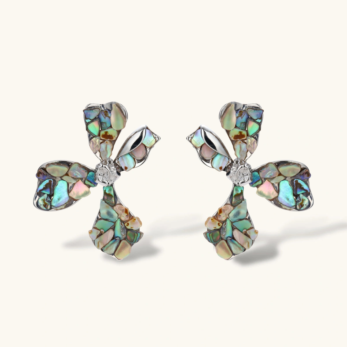Cross-shaped stud earrings with iridescent abalone shell mosaic in blues and greens, silver-plated setting with crystal center